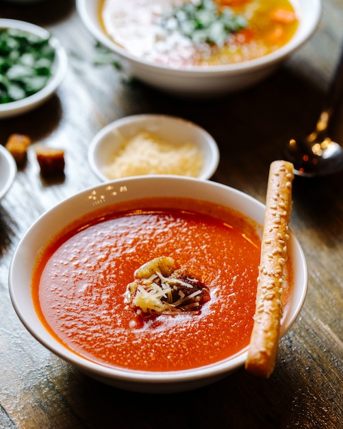 Бесплатное фото Томатный суп с сыром и крекером сверху