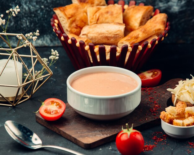 Tomato soup with crackers in white bowles.