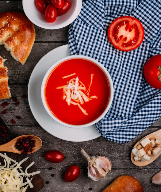 Foto gratuita zuppa di pomodoro con vista dall'alto di formaggio grattugiato sul tavolo