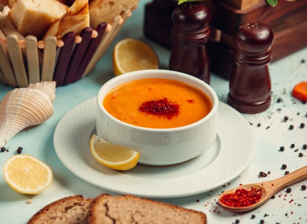 Tomato soup with paprika and lemon slices.