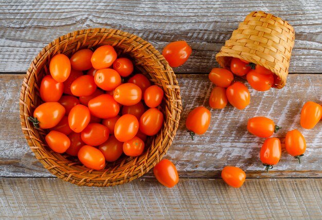 Tomatoes in baskets on a wooden table. flat lay.