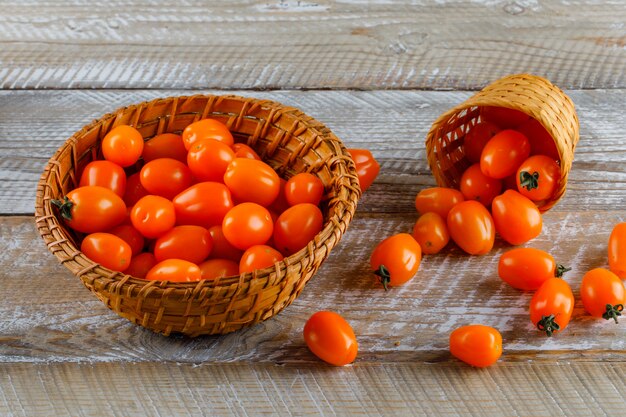 Tomatoes in baskets on a wooden table. high angle view.