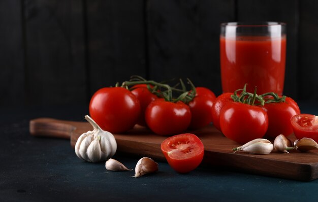 Tomatoes, garlics and a glass of juice.