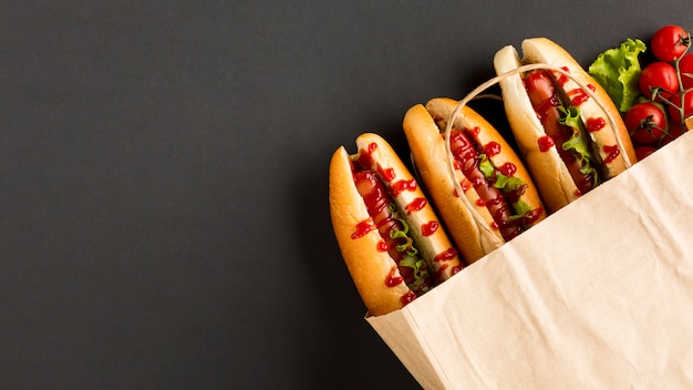 Foto gratuita pomodori e hot dog in sacchetto di plastica