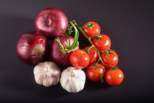 Tomatoes, onions and garlic are isolated on a black