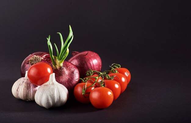 Tomatoes, onions and garlic are isolated on a black