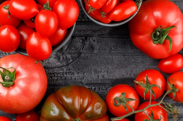 Tomatoes variety in mini buckets on grey wooden wall, close-up.