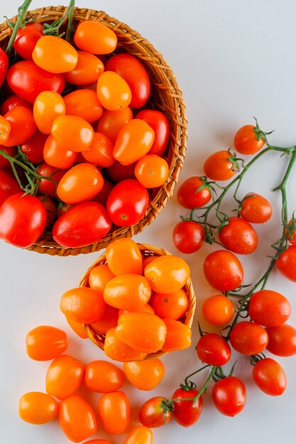 Tomatoes in wicker baskets flat lay