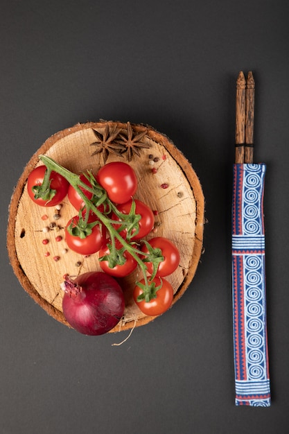Tomatoes with onion on a wooden plate