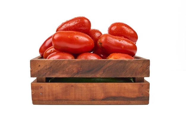 Tomatoes in wooden tray on the white.