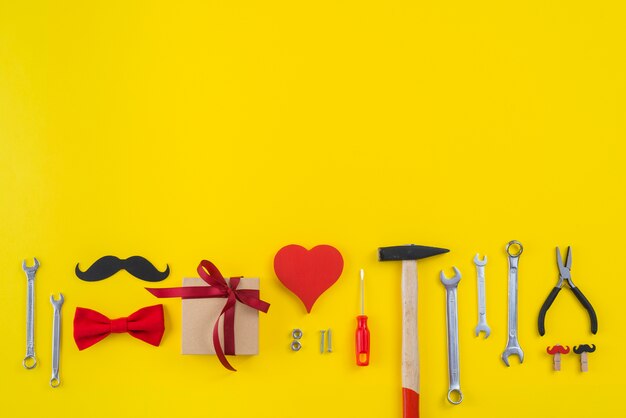 Инструменты с подарочной коробкой, бумажными усами и красным сердцем
