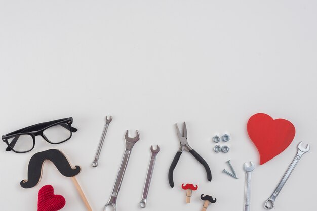 Tools with paper mustache, glasses and hearts
