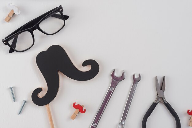 Tools with paper mustache and glasses 