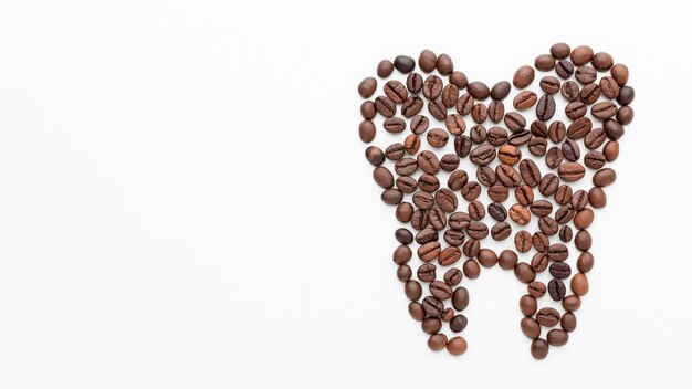 Tooth shape made of coffee beans with copy-space