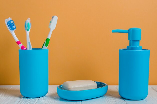 壁の白い机の上に歯ブラシの石鹸と石鹸ディスペンサーボトル