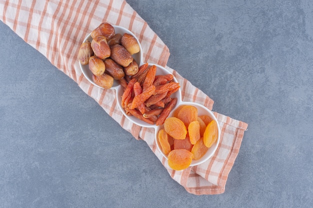 Free photo toothsome dried fruit on the towel, on the marble background.