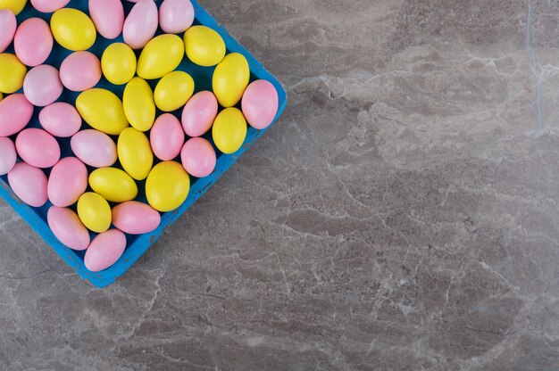 Toothsome gumball on the tray on the marble surface