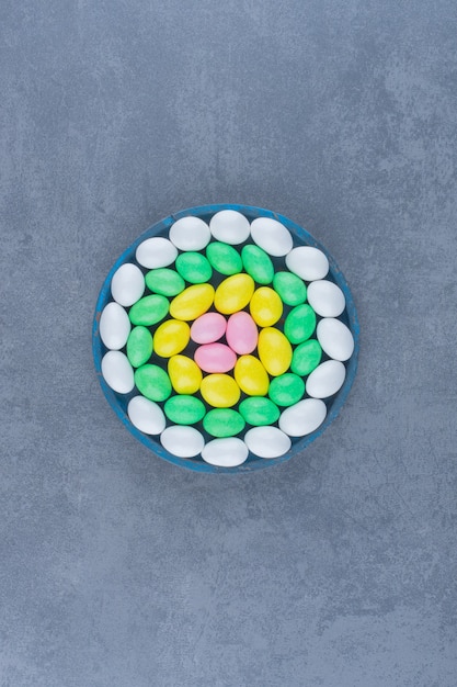 Toothsome gums in the blue plate , on the marble background. 