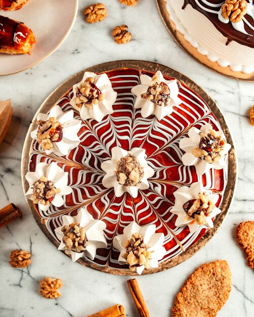 top  caramel cake decorated with meringues and walnuts on the table