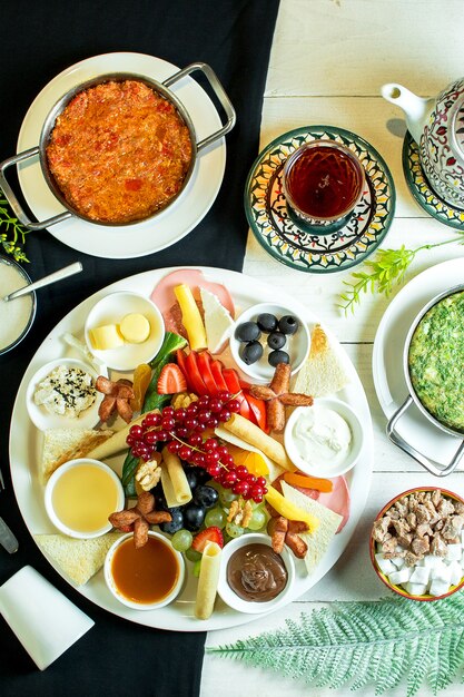 top  cheese plate served with sauces grapes and fresh fruits