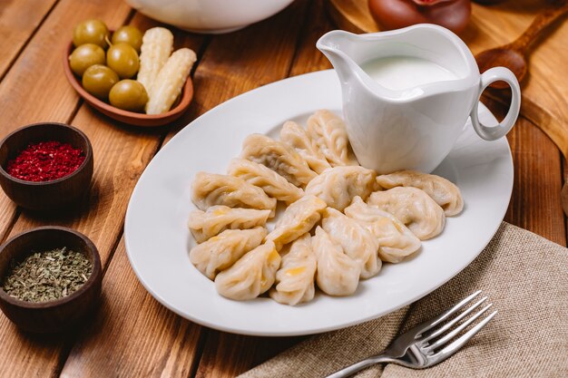 Top close up of gurza dumplings platter served with yogurt