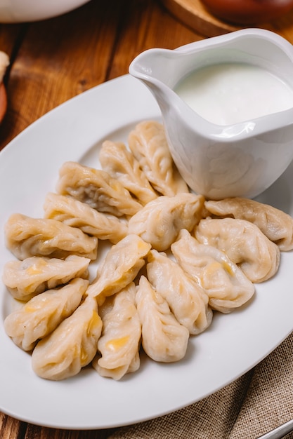 Top close up of gurza dumplings platter served with yogurt