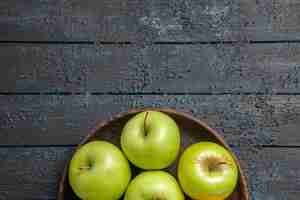 Free photo top close-up view appetizing apples seven green-yellow apples in plate on the dark surface