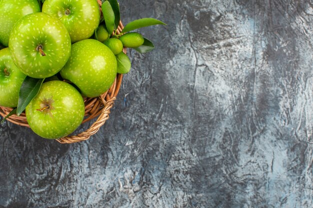 葉の柑橘系の果物と青リンゴの上部のクローズアップビューリンゴバスケット