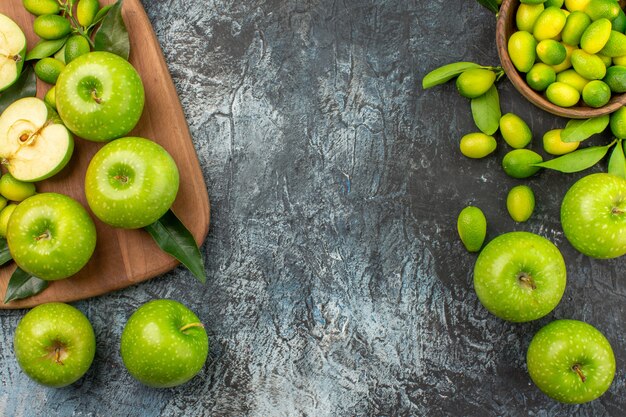 Top close-up view apples citrus fruits in the bowl the appetizing apples on the board