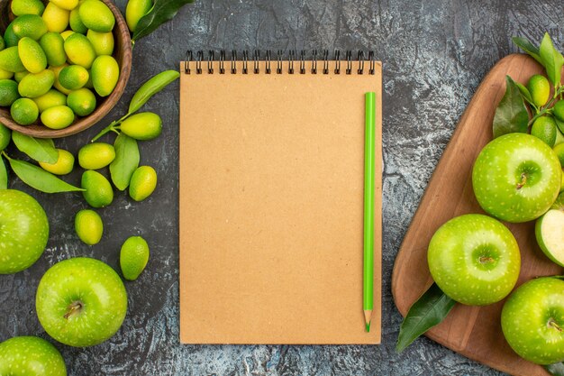 上部のクローズアップビューリンゴ柑橘系の果物緑のリンゴの葉とボードノート鉛筆