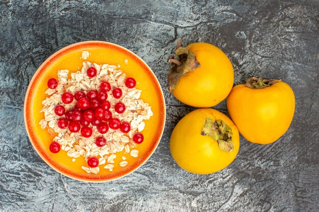 Top close-up view berries berries in the bowl the appetizing persimmons