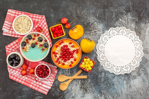 Top close-up view berries berries oatmeal on the white-pink tablecloth yellow candies lace doily