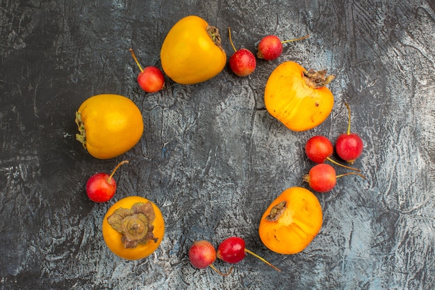 Top close-up view berries cherry the appetizing persimmons are laid out in a circle