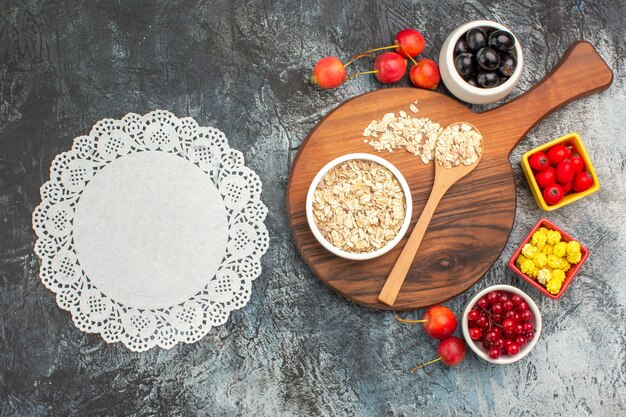 Top close-up view berries lace doily cherries oatmeal on the board berries yellow candies