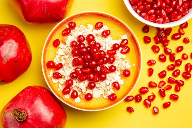 Top close-up view berries pomegranate seeds red currants oatmeal in the bowls