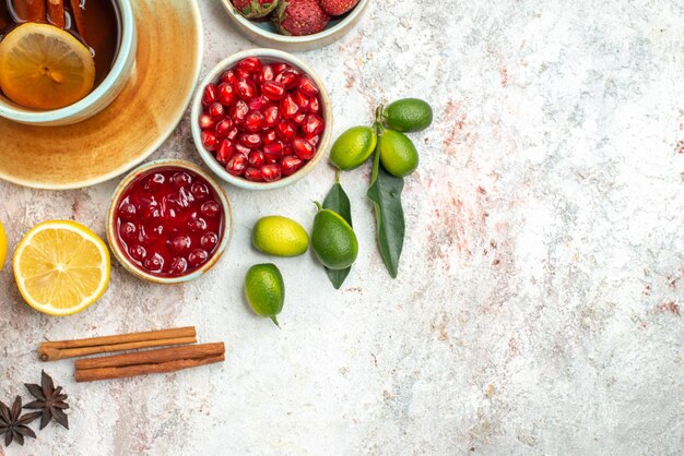 Top close-up view berries and tea a cup of tea with cinnamon sticks citrus fruits berries cookies