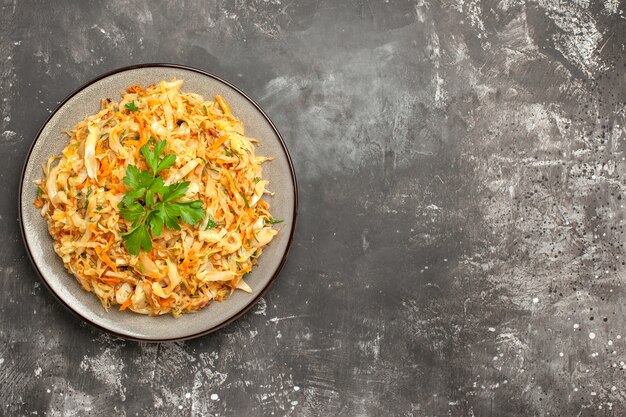 Top close-up view cabbage the appetizing cabbage with carrots herbs on the white plate