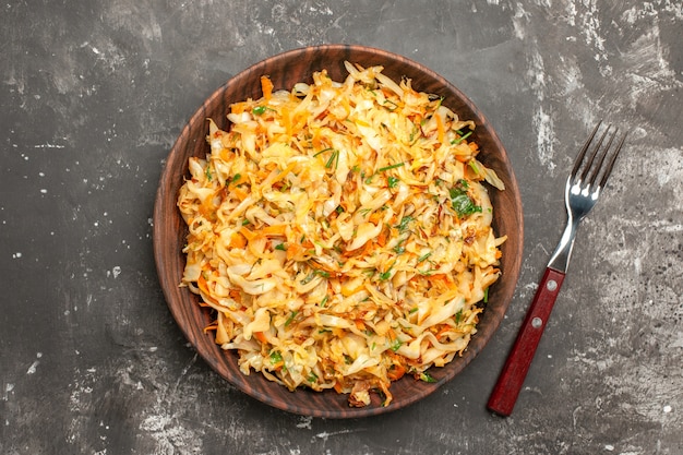 Top close-up view cabbage with carrots the plate of the appetizing carrots and cabbage fork