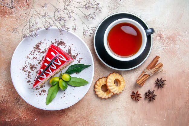 Top close-up view a cake an appetizing cake a cup of tea cookies star anise cinnamon sticks