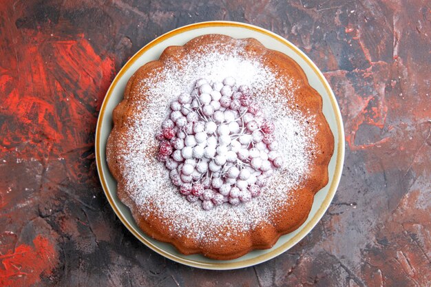 Top close-up view a cake an appetizing cake with berries and powdered sugar