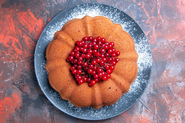 Top close-up view cake an appetizing cake with red currants on the grey plate