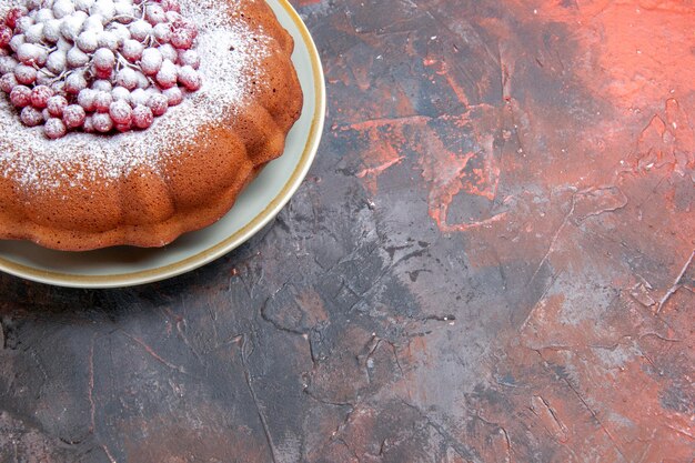 Top close-up view a cake an appetizing cake with red currants on the red-blue table