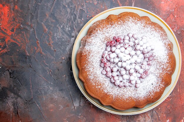 Top close-up view a cake an appetizing cake with red currants on the white plate