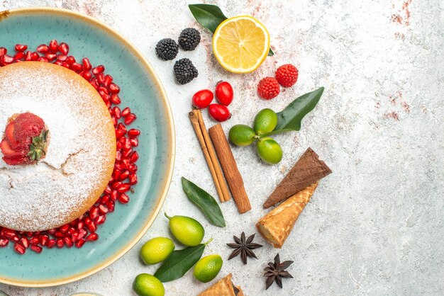 Top close-up view a cake an appetizing cake with strawberries cinnamon sticks berries star anise