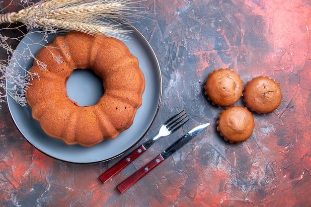 Free photo top close-up view a cake the appetizing cupcakes cake fork knife wheat ears and branches