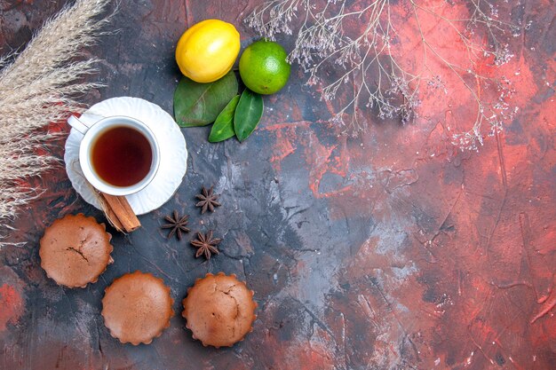 Top close-up view cake the appetizing cupcakes a cup of tea citrus fruits with leaves