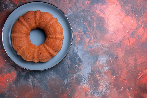 Top close-up view cake blue plate of an appetizing cake on the blue-red table