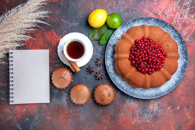 無料写真 ベリーと柑橘系の果物のカップケーキとお茶のノートブックスターアニスのトップクローズアップビューケーキケーキ