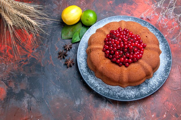 Top close-up view cake cake with berries lemons limes leaves star anise wheat ears