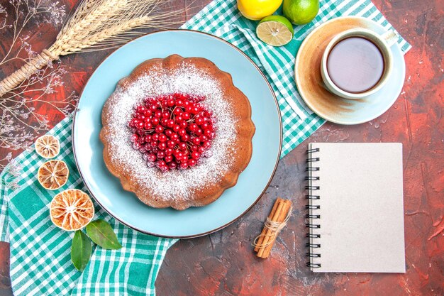 상위 클로즈업 보기 케이크 테이블보에 딸기 라임이 있는 케이크 흰색 차 한 잔